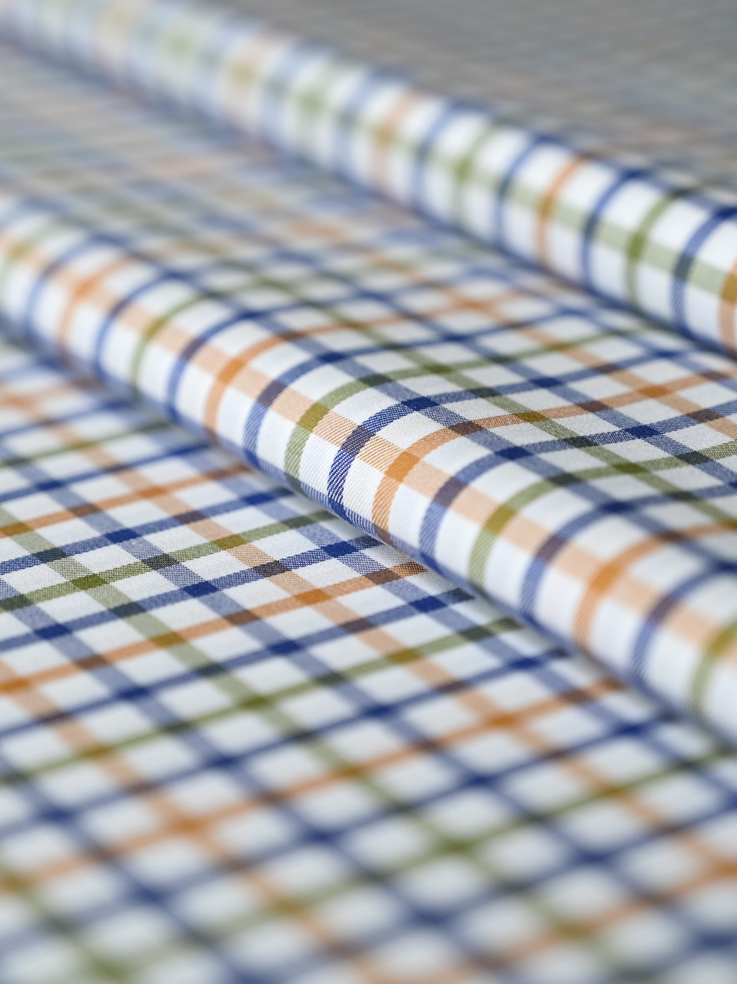 Vibrant multicolor check fabric featuring blue, green, and orange patterns on a white backdrop for men's fashion.