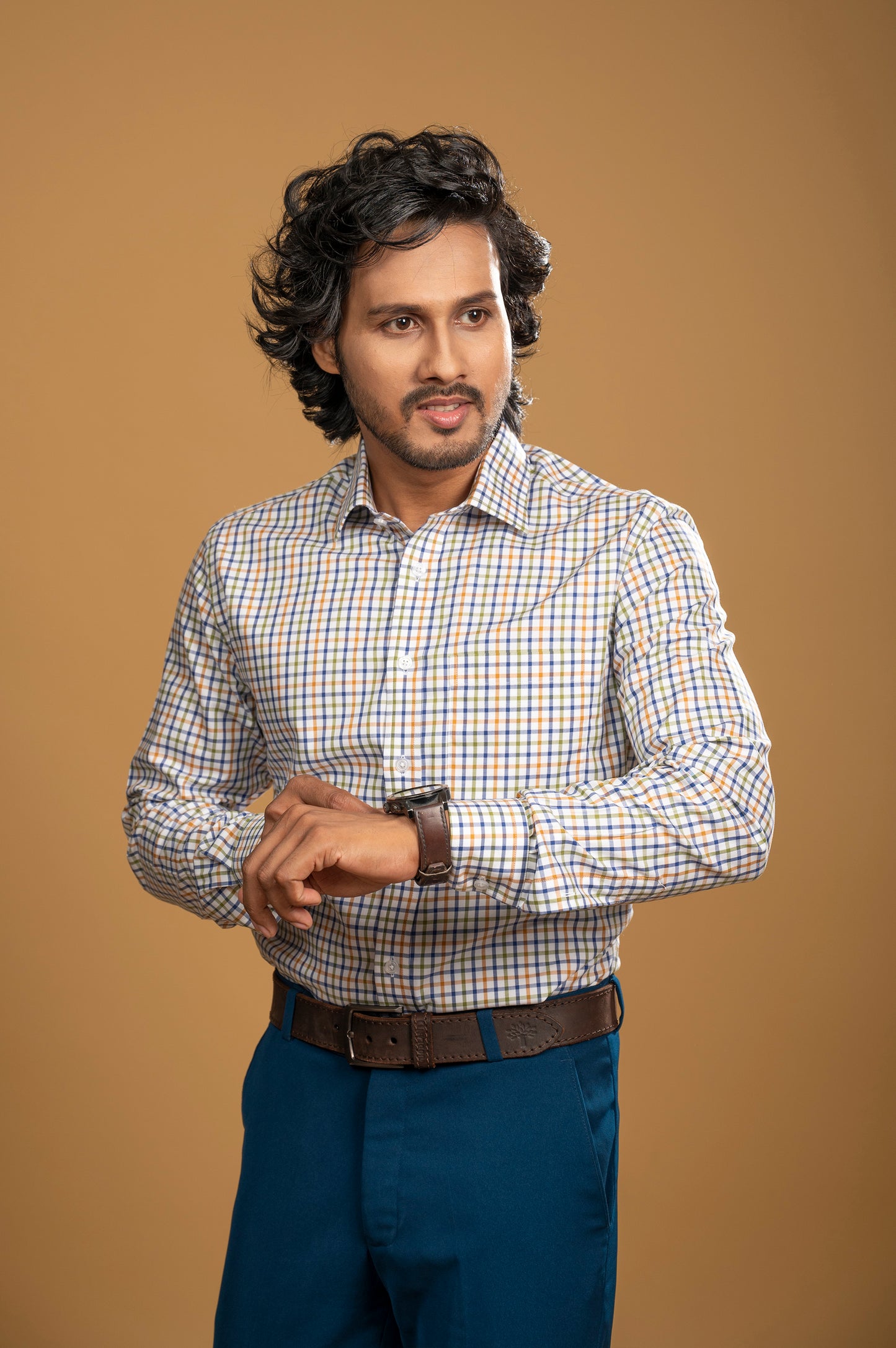 Stylish man in a vibrant multicolor check shirt, showcasing modern men's fashion with confidence.
