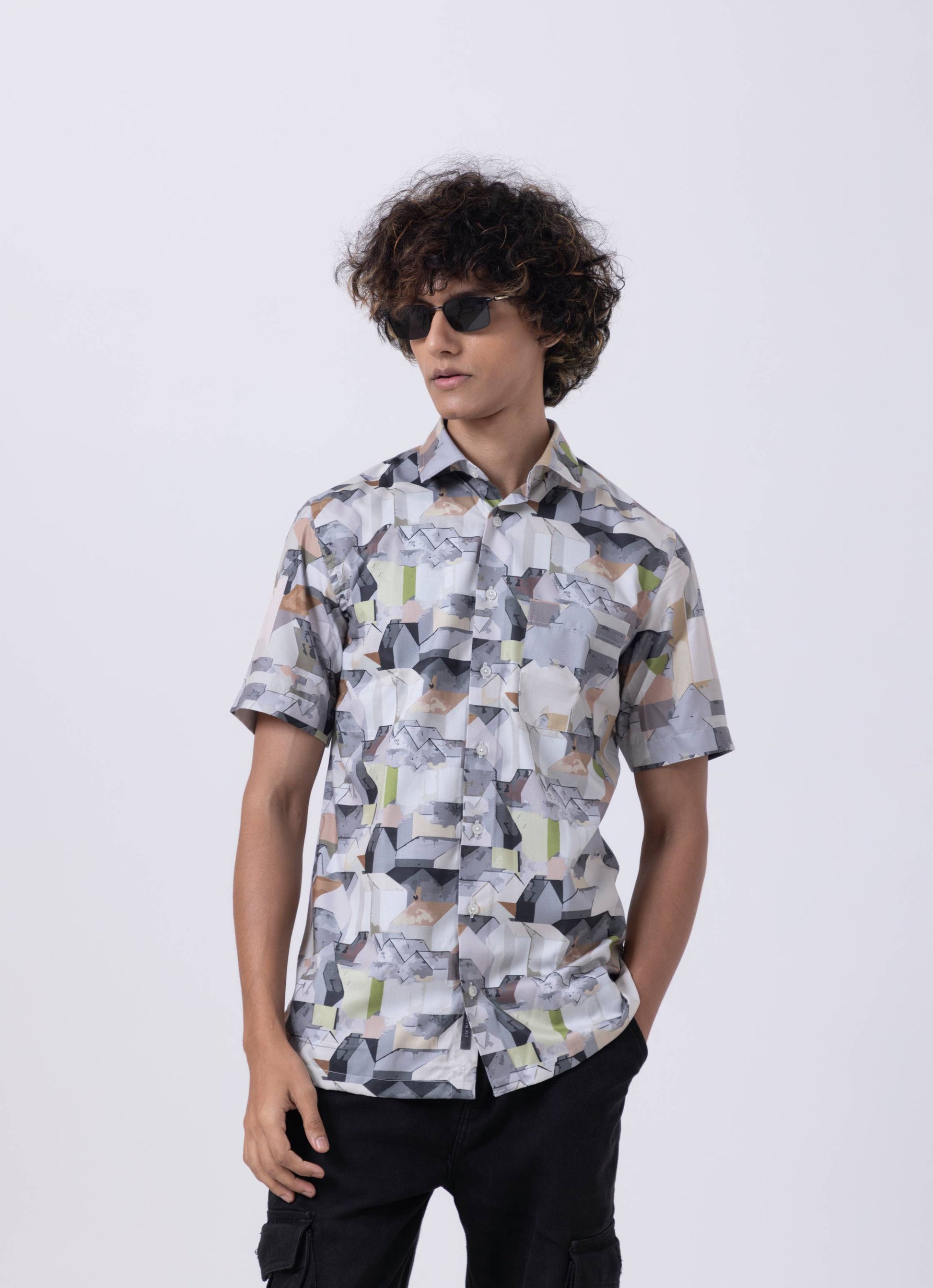 Multicolor abstract print slim fit shirt model wearing stylish sunglasses, showcasing modern fashion for professionals.