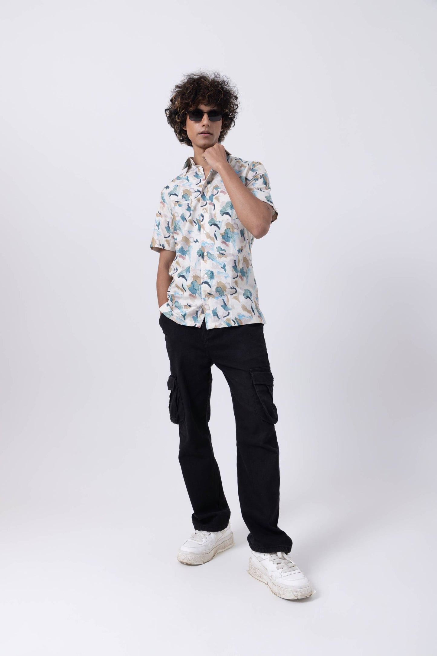 Model wearing a Tropical Print Slim Fit Shirt with cargo pants and sunglasses, showcasing vibrant patterns and style.