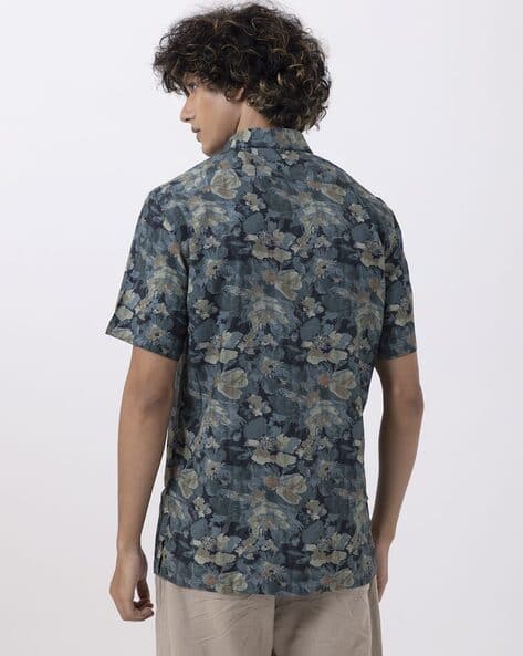 Back view of a man wearing a jungle print half-sleeve shirt, showcasing unique men's fashion in teal linen.