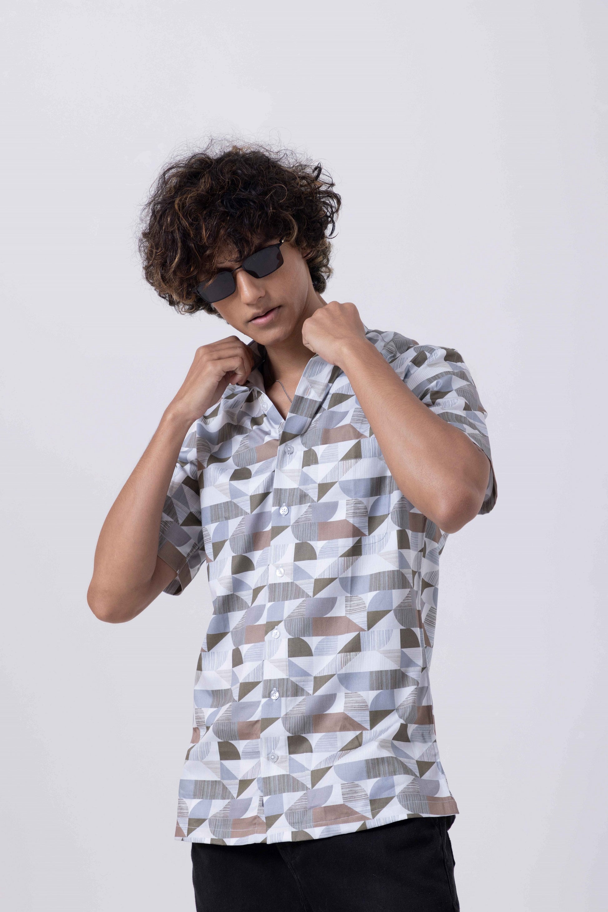 Man wearing The Man Printed Slim Fit Shirt with geometric prints, showcasing stylish design and contemporary appeal.