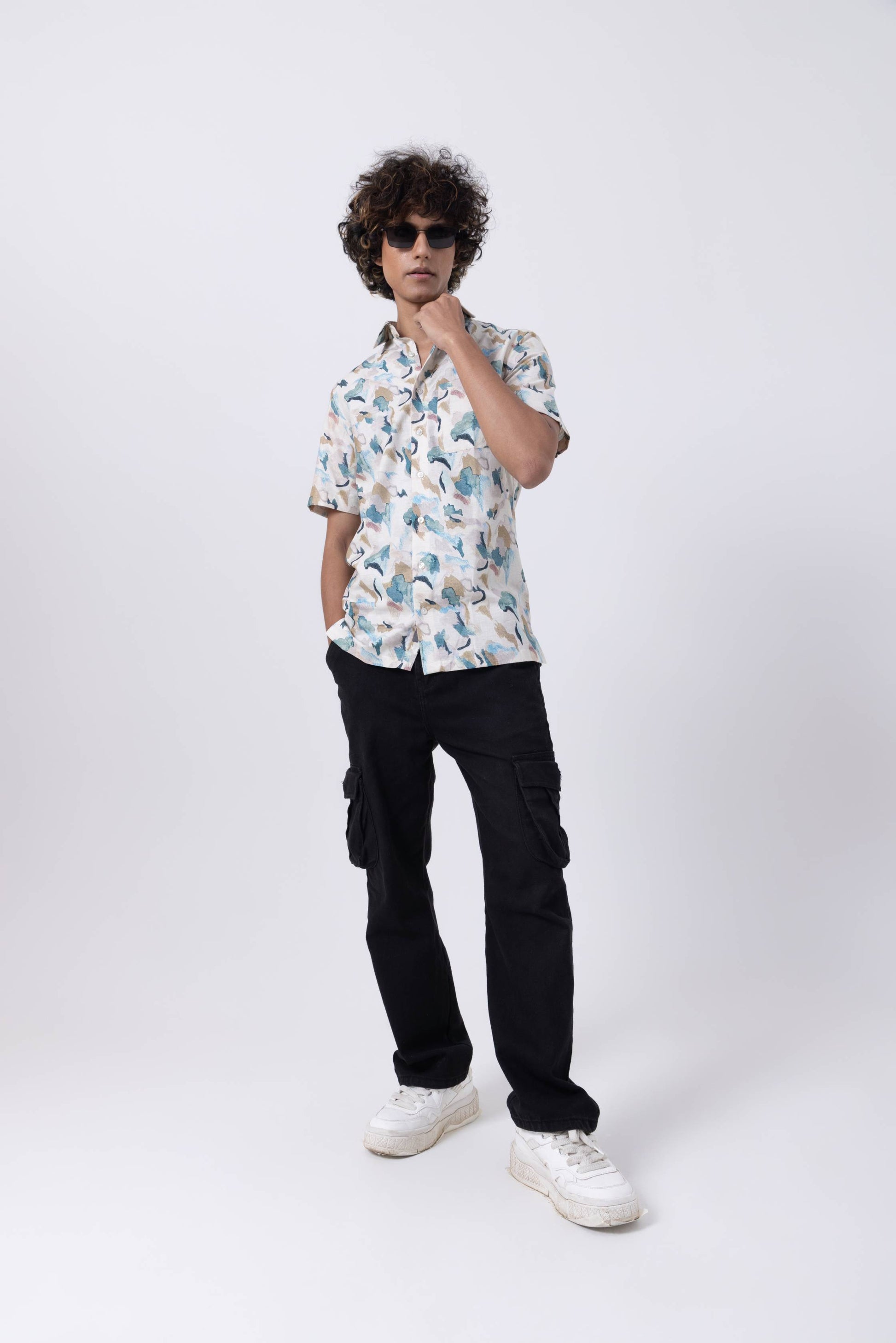 Model wearing a Tropical Print Slim Fit Shirt with cargo pants and sunglasses, showcasing vibrant patterns and style.